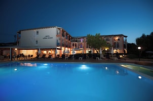 Um hotel com piscina, área de estar externa e bar.
