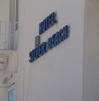 Un letrero para un hotel llamado 'Hotel Silver Beach'.