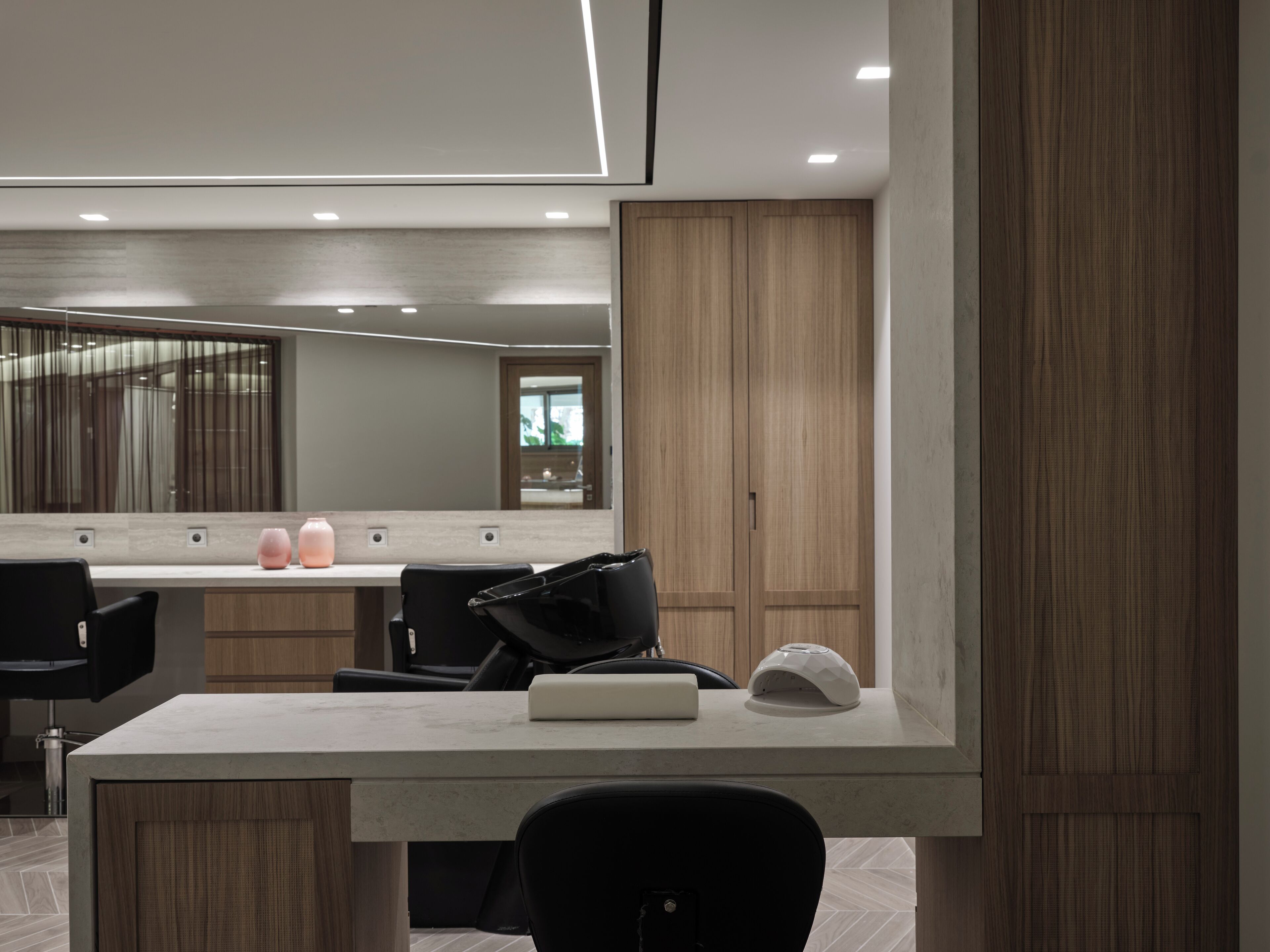 Un baño moderno con un espejo grande, armarios de madera y una encimera blanca.