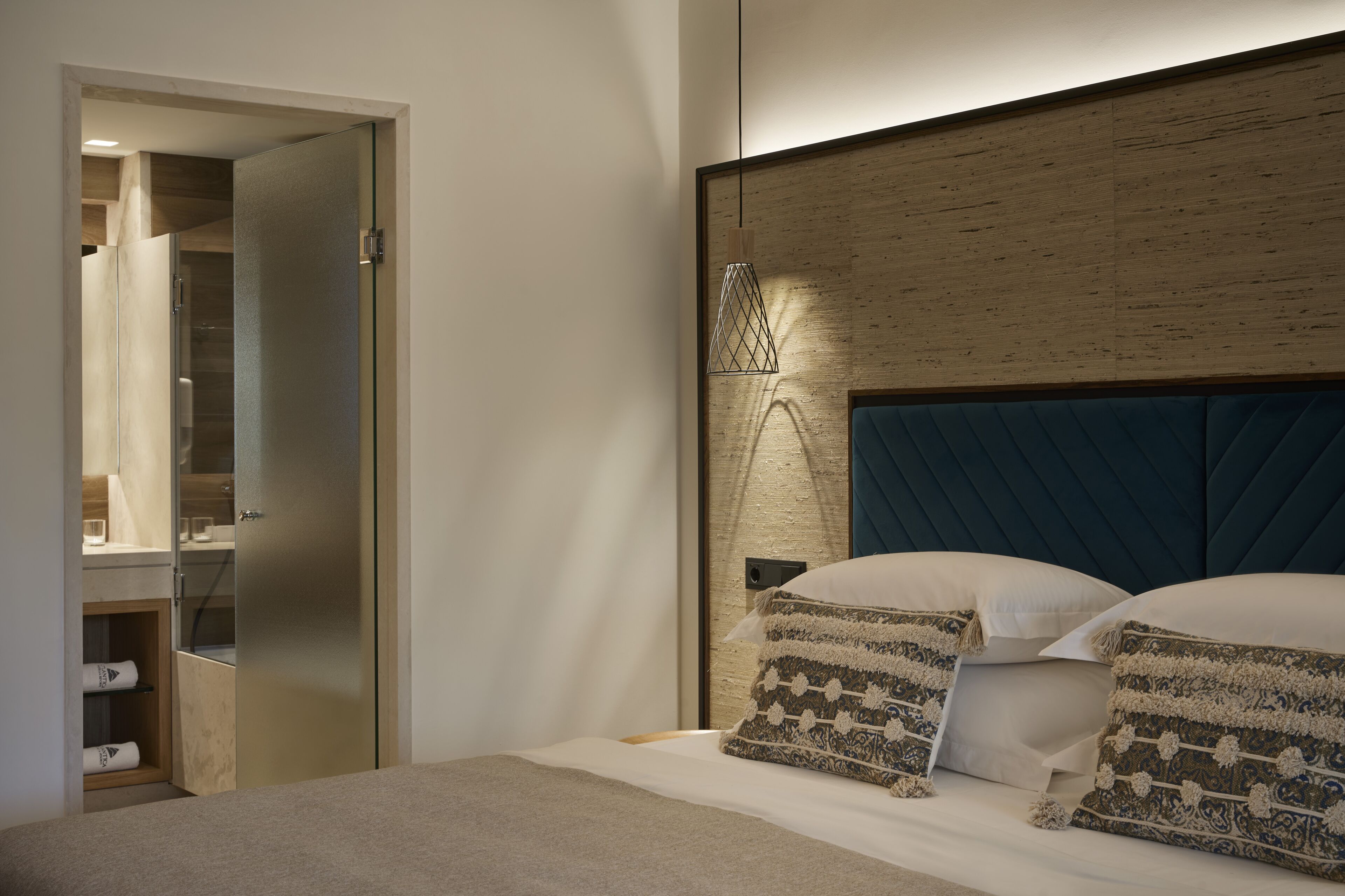 A modern bedroom with a large bed, a wooden headboard, and a built-in wardrobe.