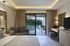A modern hotel room with a bed, a desk, a television, and a view of an outdoor pool area. - Atlantica Aegean Blue - All Inclusive (Rhodes)