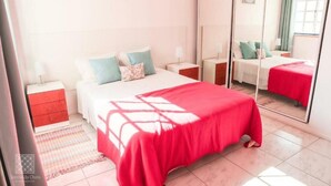 A bedroom with a large bed, a mirror, and a nightstand. - Sereia da Oura (Albufeira)