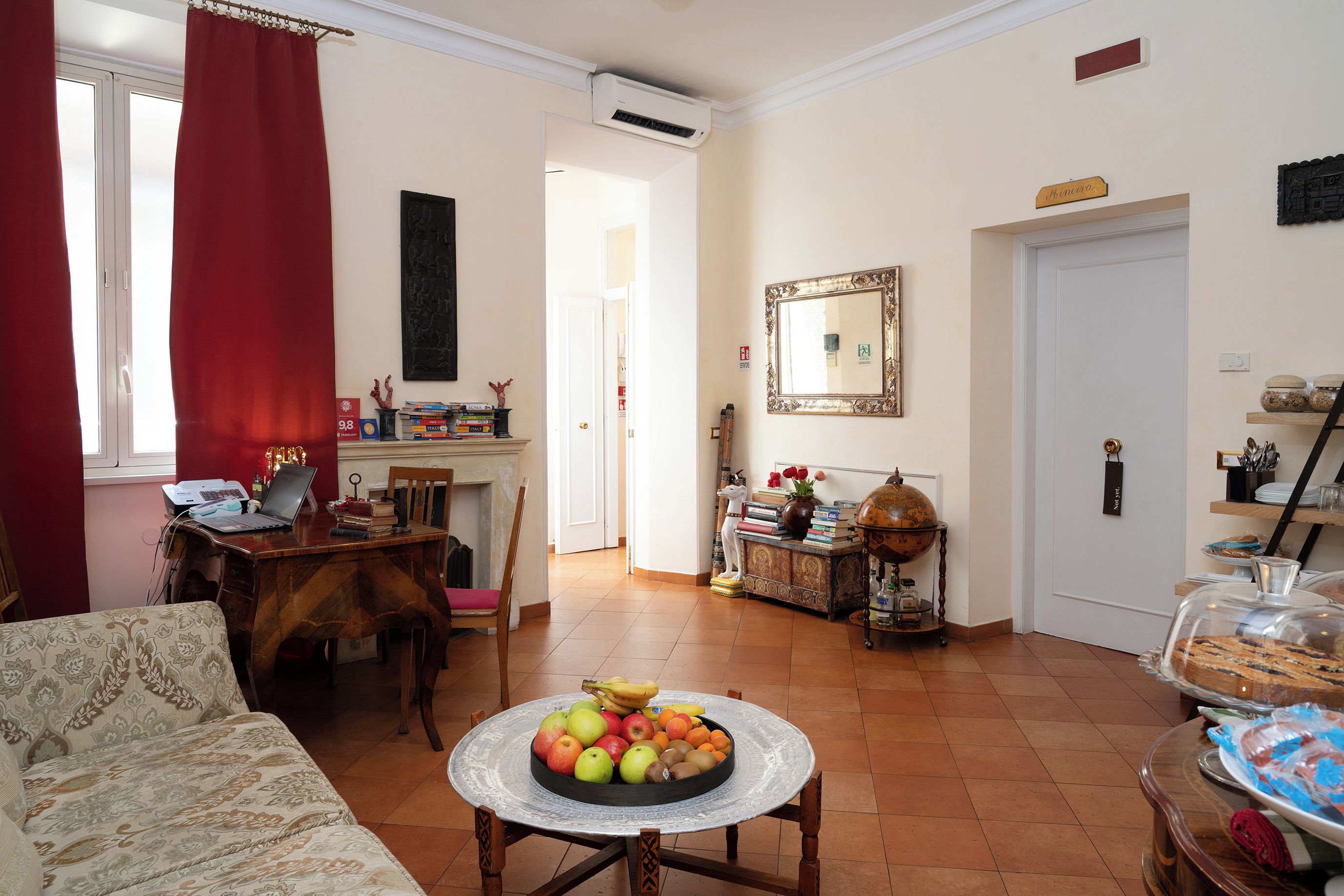Un salon comprenant un coin repas, une cheminée, un globe terrestre et un panier de fruits.