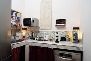 Una cucina moderna dotata di microonde, tostapane, macchina per il caffè e caffettiera.
