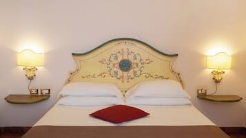 Un lit avec une tête de lit décorative, deux lampes de chevet et un oreiller rouge.