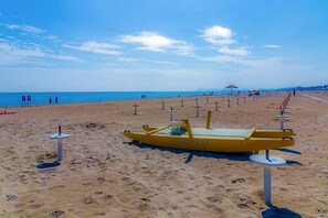 A beach with a yellow boat and sun loungers. - La Fiorita (Rimini)