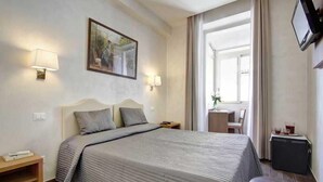 Habitación de hotel con cama, lámparas de noche, televisor y ventana.