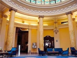 A grand lobby with a circular ceiling, large columns, and blue seating. - Gran Hotel Bolivar (Lima)