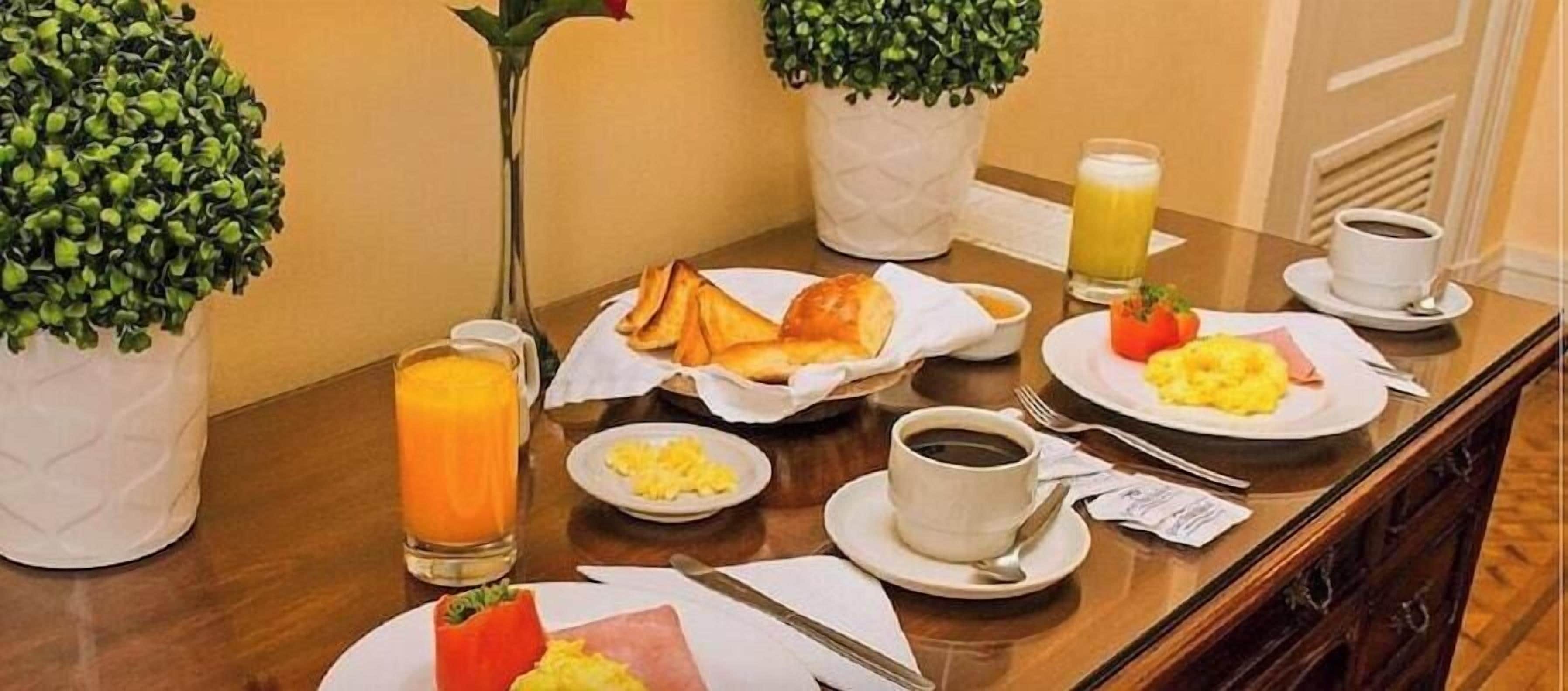 Buffet de l'esmorzar amb plats variats, racó de cafè i plantes en testos.