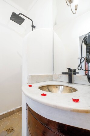 A bathroom with a toilet, a shower head, and a hairdryer. - Riad Chalymar (Marrakech)