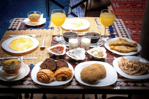 Une table de petit-déjeuner avec divers plats et boissons.