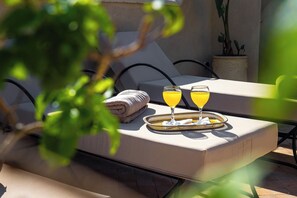 A sun lounger with a tray containing two glasses of orange juice and a folded towel. - Riad Chalymar (Marrakech)