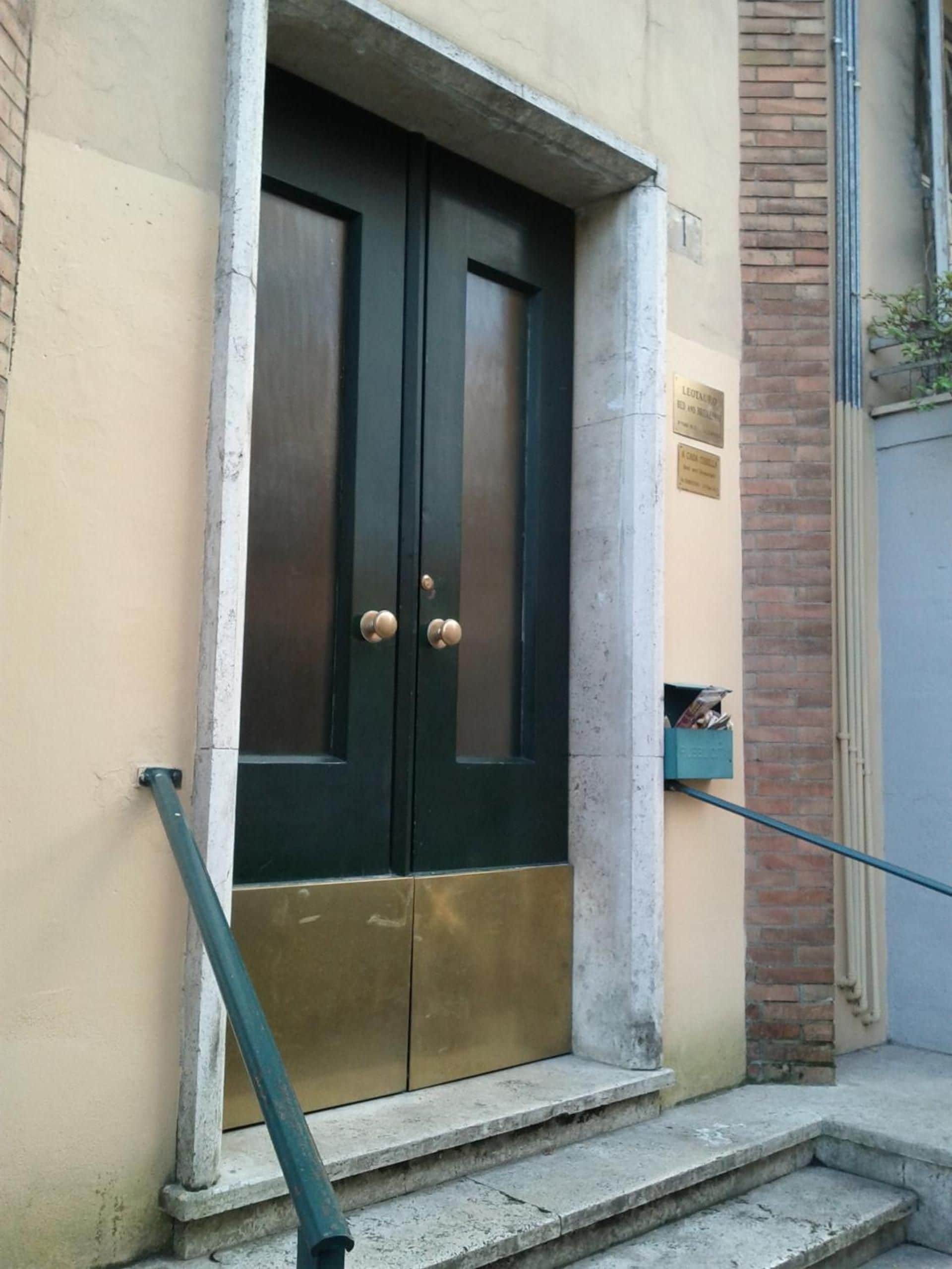 A double door with brass handles, a mailbox, and a small step leading to the entrance.