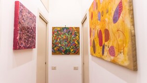 Um corredor com três obras de arte nas paredes.