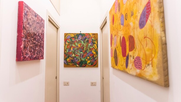 A hallway with three artworks on the walls. - A Casa Cibella (Rome)