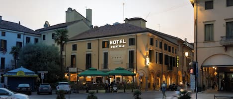 A hotel with outdoor seating and a sign indicating a restaurant.