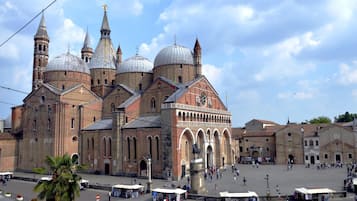 Una iglesia histórica con múltiples cúpulas y campanarios, rodeada por una plaza con gente y puestos de mercado.