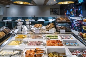 Un buffet proposant une variété de plats et un espace détente avec des bancs bleus rembourrés.