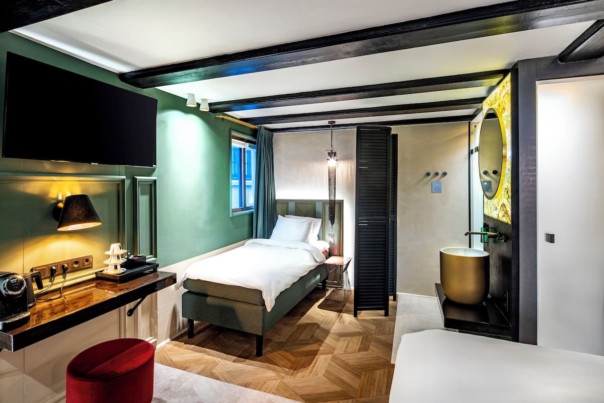 Un dormitorio moderno con cama, mesita de noche y un espejo grande.
