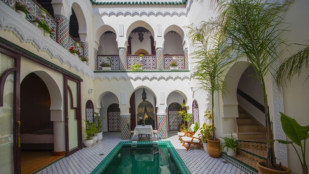 A courtyard with a pool, potted plants, and a staircase. - Riad Maison Belbaraka (Marrakech)