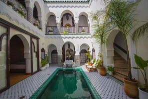 A courtyard with a pool, potted plants, and a staircase. - Riad Maison Belbaraka (Marrakech)