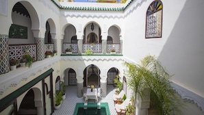 A courtyard with arches, a pool, and potted plants. - Riad Maison Belbaraka (Marrakech)