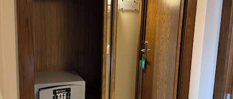 A wooden closet with a built-in safe and a door leading to a stairwell.