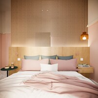 Un dormitorio con cabecera de listones de madera, cama con ropa de cama rosa, dos mesitas de noche con lámparas y un buró con un libro.