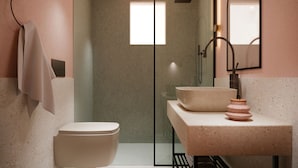 Een moderne badkamer met toilet, wastafel en douche.