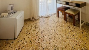 A small, clean room with a kitchenette, a mirror, and a window with sheer curtains. - Asteria (Zakynthos)