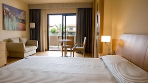 A hotel room with a large bed, a sofa, a small table with chairs, a lamp, and a painting on the wall. - El Delfin Verde (Torroella de Montgri)