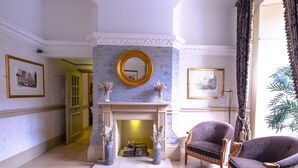 A room with a marble fireplace, two framed pictures, and a large window with curtains. - The Royal Hotel (Bath)