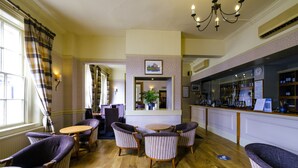 A hotel lobby with a bar area, seating arrangements, and a mirror reflecting the space. - The Royal Hotel (Bath)