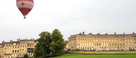 A large building with multiple windows and a lawn in front.