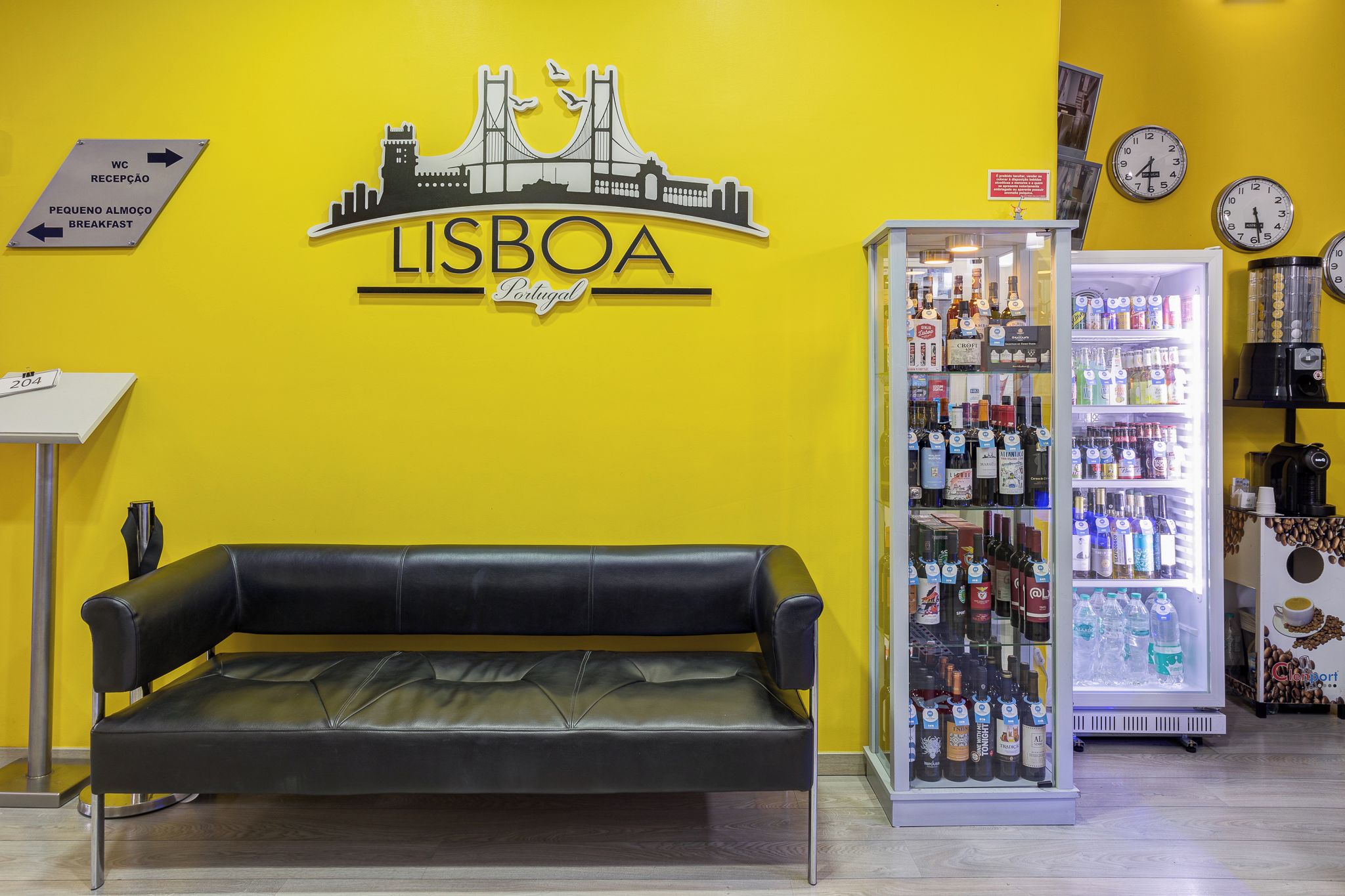 A Lisbon-themed wall with a couch and a beverage refrigerator.