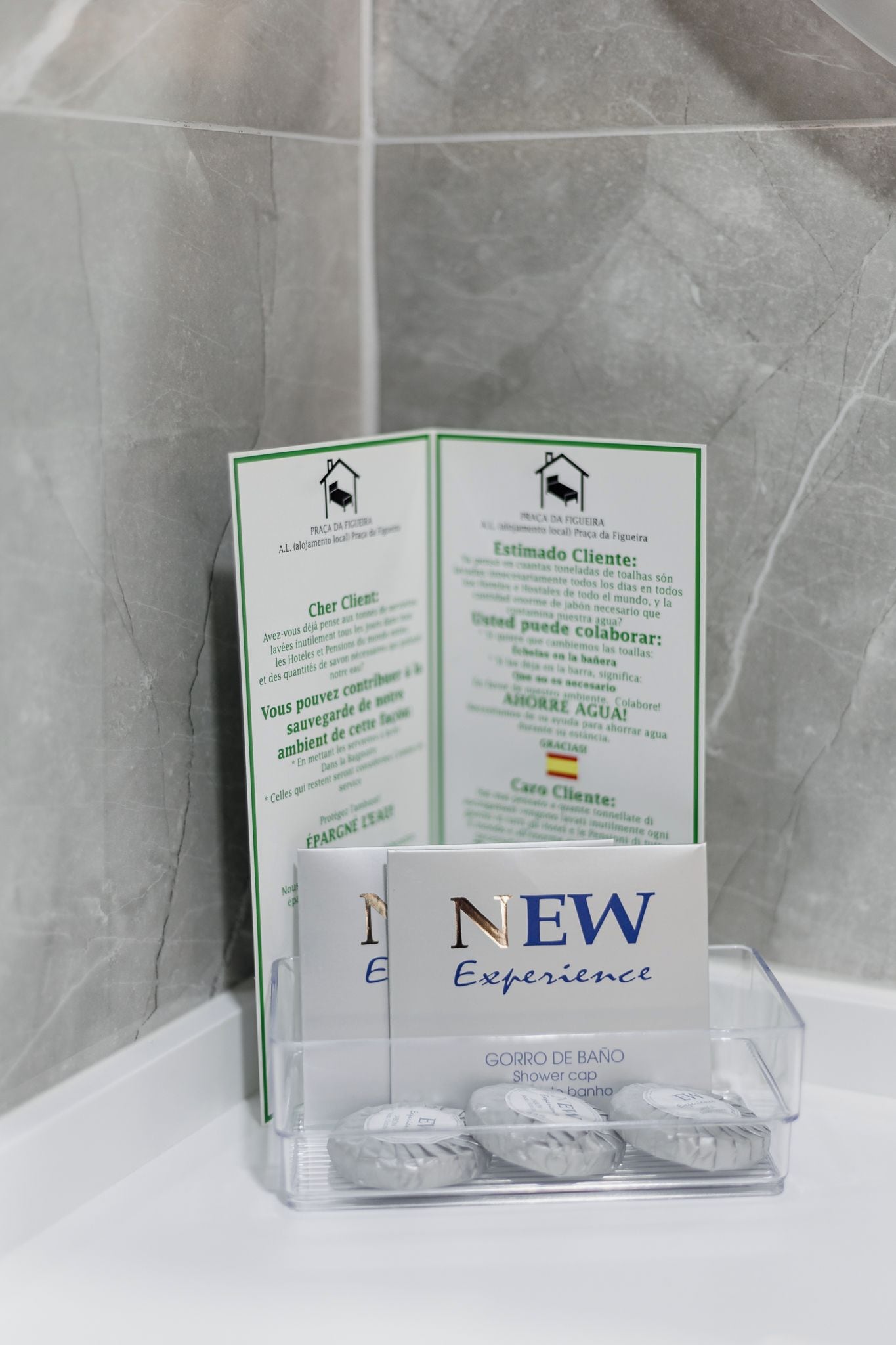 Un expositor con un folleto y una caja de producto con el texto 'NEW Experience' para una gorra de ducha.