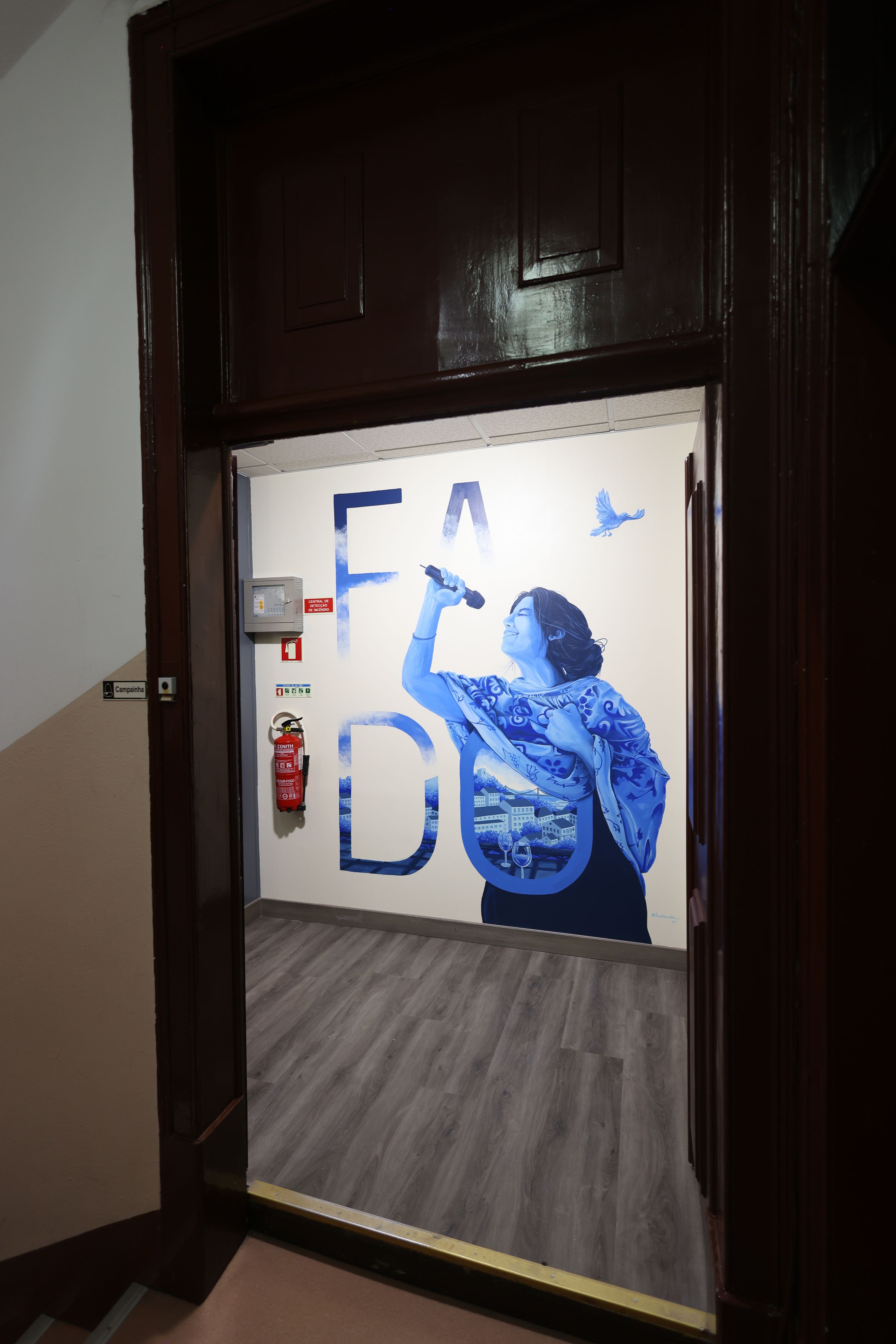 A door with a large blue and white graphic of a woman holding a microphone, with the letters 'FA' and 'DO' visible.