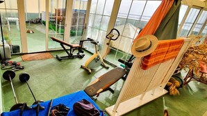 A gym with exercise equipment, a bench, and a large window. - Apartamentos Mayoysa (Brena Baja)
