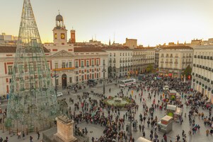 Ein belebter Platz mit einer großartigen, verzierten Struktur in der Mitte, umgeben von historischen Gebäuden.
