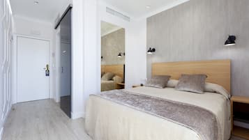 Un dormitorio moderno con una cama grande, mesitas de noche y un armario.