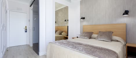A modern bedroom with a large bed, bedside tables, and a wardrobe.