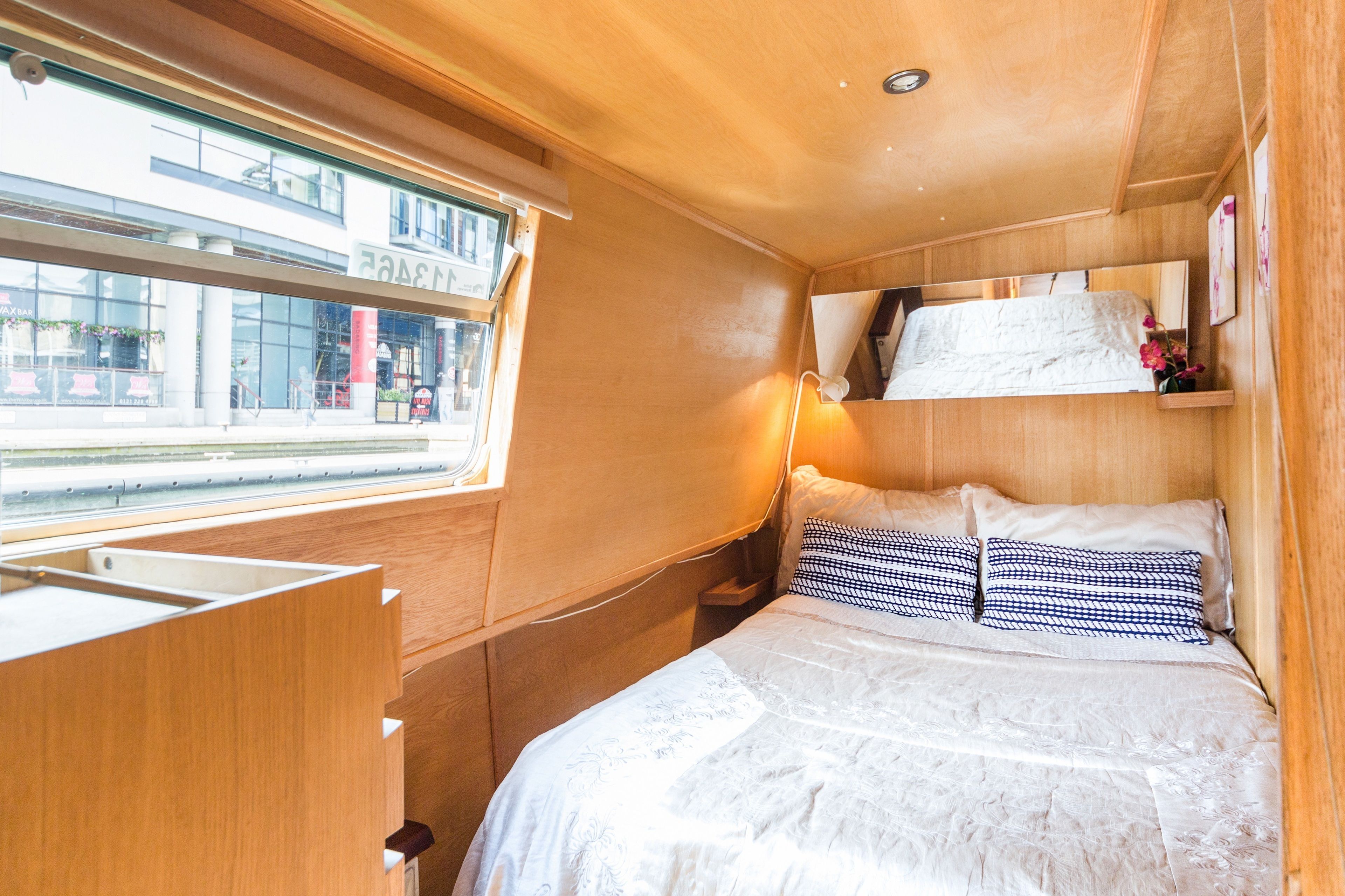 A compact bedroom with a bed, bedside table, and a window.