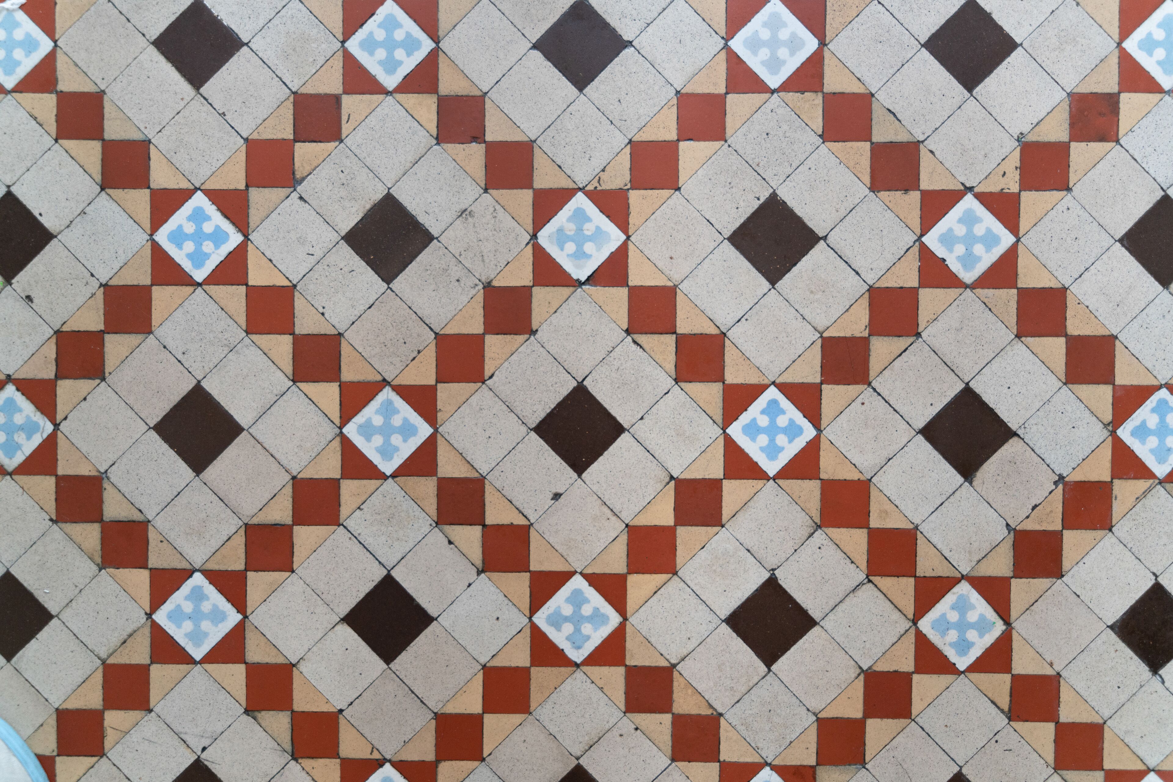 A patterned tile floor with a repeating diamond design.
