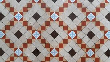A patterned tile floor with a repeating diamond design.