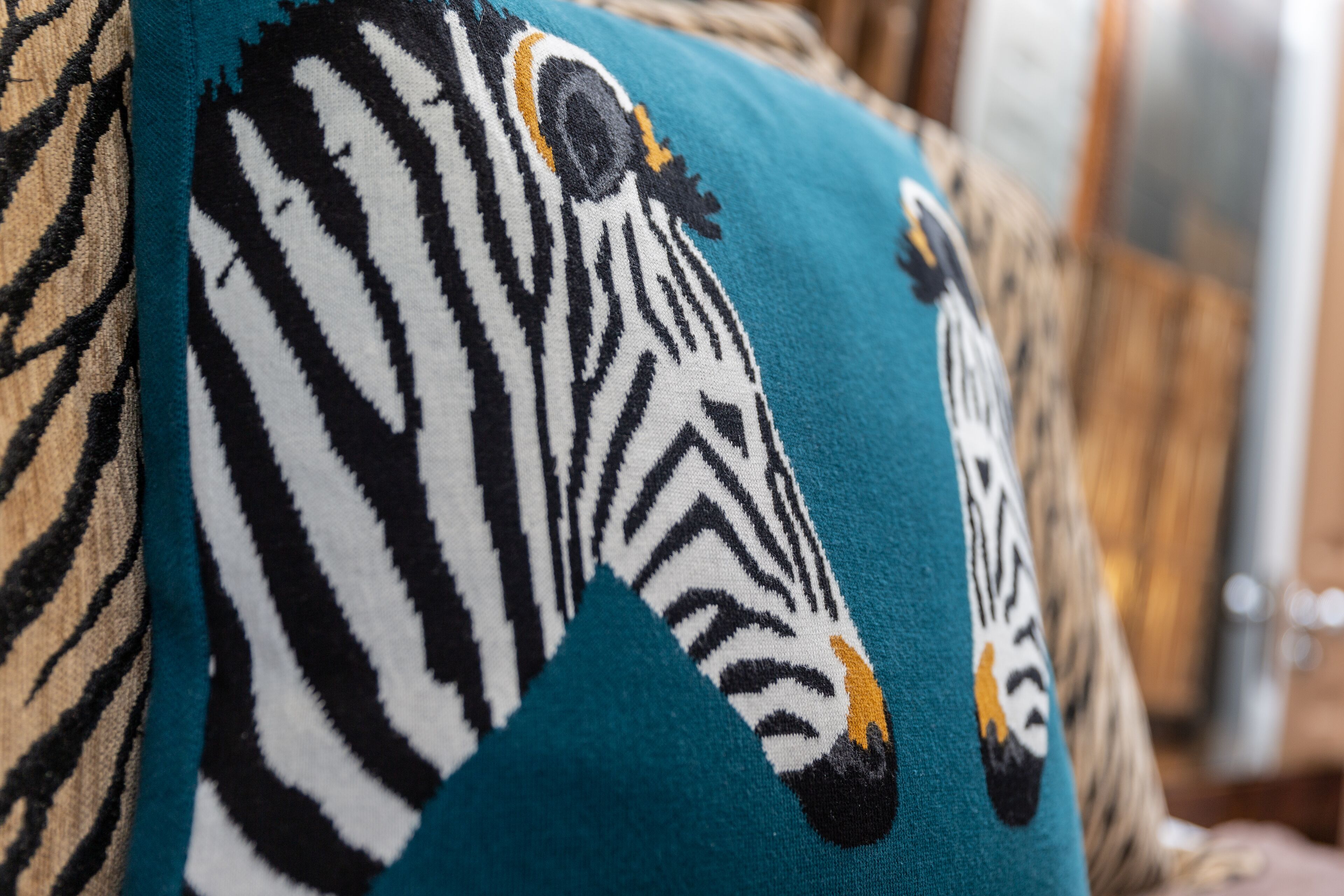 A close-up of a zebra-patterned pillow on a couch.