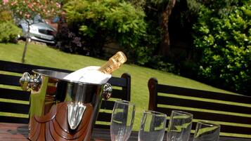 Un montaje para picnic con una botella de champán, copas y una bandeja sobre una mesa de madera.