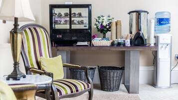 A breakfast bar with a refrigerator, wicker baskets, a water dispenser, and striped chairs.