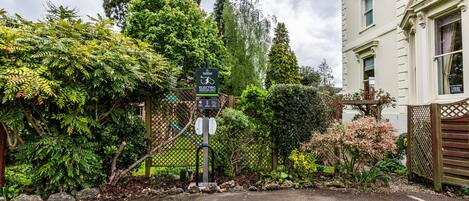 A gated entrance with a sign indicating electric vehicle charging facilities.