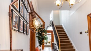 A staircase with a wooden handrail and a wall adorned with framed pictures. - Beaumont House (Cheltenham)