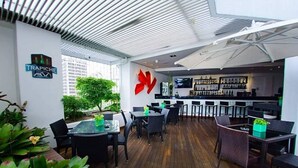 Un restaurant au design moderne, doté d’un bar, d’une terrasse et offrant une vue sur la ville.
